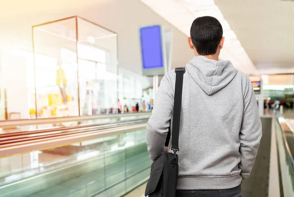 空港の動く歩道に立っている認識できない若い男のレビューショット — ストック写真