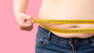 Şişman, kilolu, beyaz arka planda izole edilmiş kilosunu kontrol eden kıza yaklaş.