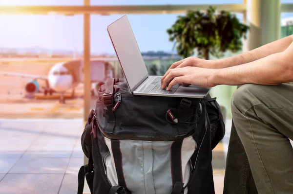 在机场 一个无法辨认的数字游牧民族独自坐在笔记本电脑上打字 — 图库照片
