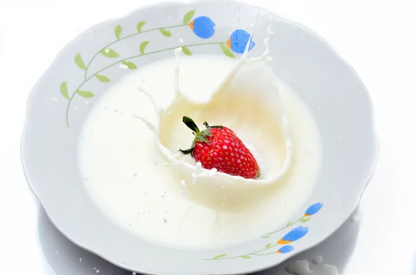 Delicious strawberry splashing into milk — Stock Photo, Image