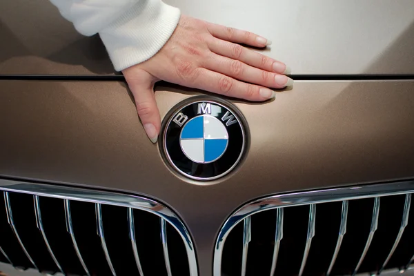 Woman's hand on BMW logo — Stock Photo, Image