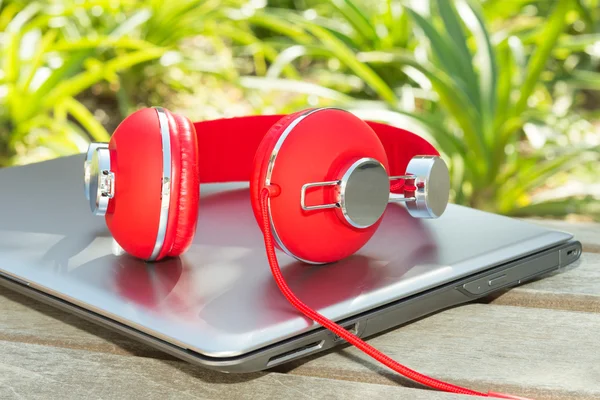 Vivid red headphones and laptop — Stock Photo, Image