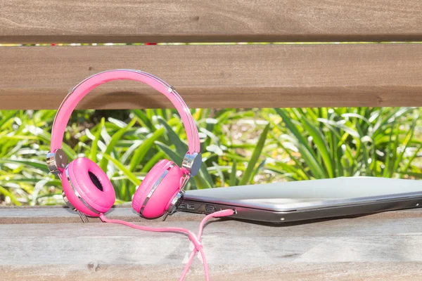 Vividl rosa hörlurar och laptop — Stockfoto