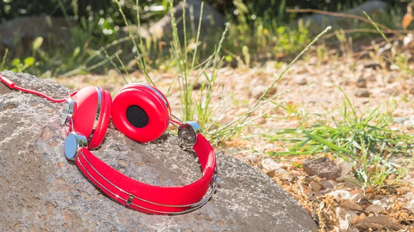 Vivid red wired headphones on the stone — Stock Photo, Image