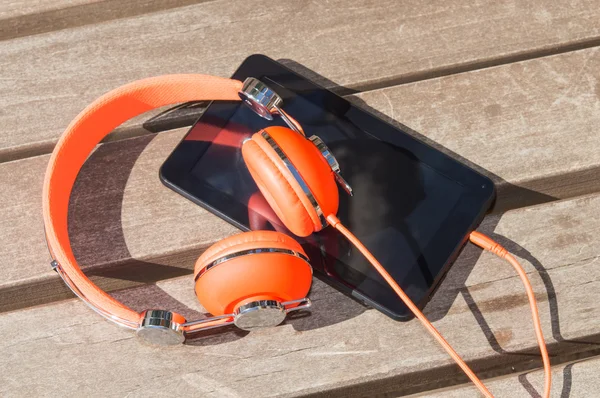 Orange hörlurar och TabletPC — Stockfoto