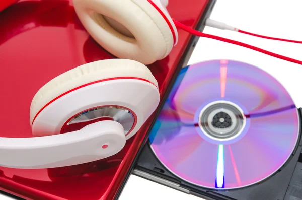 Computador portátil com disco de DVD e auscultadores brancos vermelhos — Fotografia de Stock