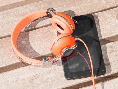 canlı turuncu kulaklık ve siyah tablet PC'de ahşap Bank