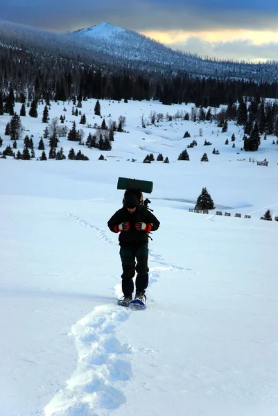 El hombre va en las montañas raquetas de nieve —  Fotos de Stock