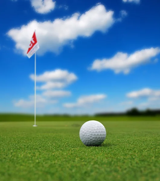 Golf ball in front of flag — Stock Photo, Image