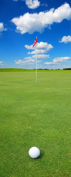 Golf ball in front of flag — Stock Photo, Image