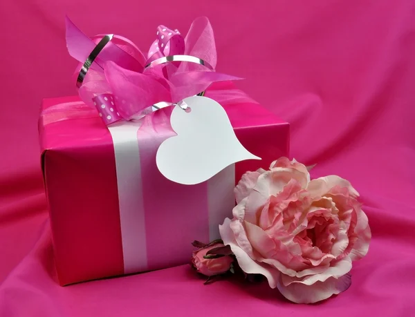 粉红色女士提出的礼物与玫瑰 — 图库照片