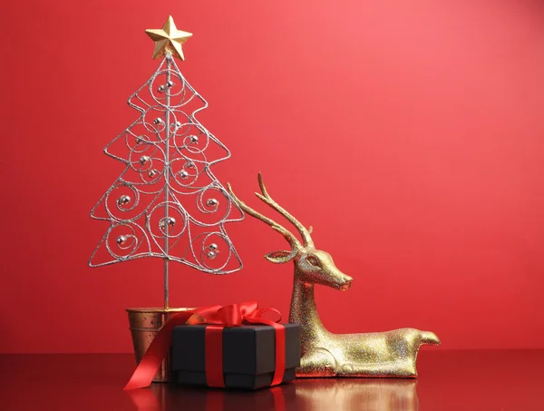 シルバーとゴールドのキラキラ クリスマス ツリーと黒と赤のトナカイの装飾のギフトを示す — ストック写真