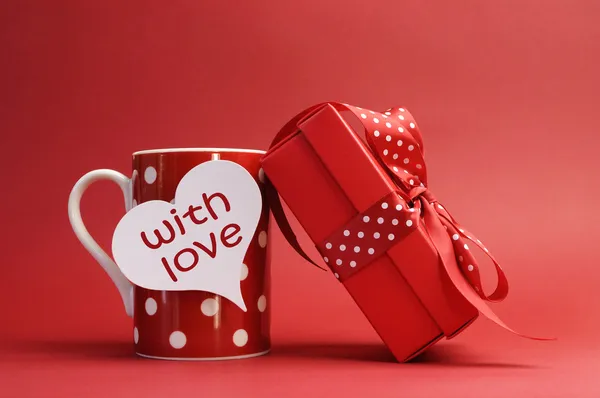 Valentines Day "With love" message on red polka dot mug and red gift with red bow — Stock Photo, Image