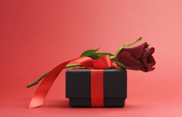 Glad Alla hjärtans dag svart låda med rött band gåva och röd ros — Stockfoto