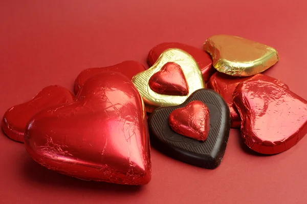 Chocolates em forma de coração vermelho e dourado — Fotografia de Stock