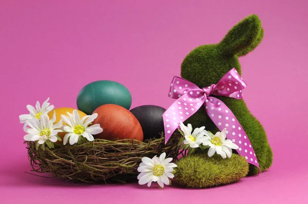 Tema rosa Feliz Páscoa ainda vida com coelho grama coelho com ovos de cor do arco-íris em um ninho — Fotografia de Stock