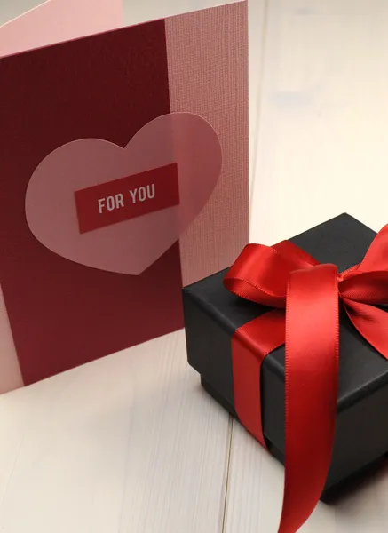 Χειροποίητο δώρο κάρτα, «για σας», με δώρο μαύρο κουτί και κόκκινης κορδέλλας σε λευκό φυσικό ξύλινο επιτραπέζιο. — Φωτογραφία Αρχείου