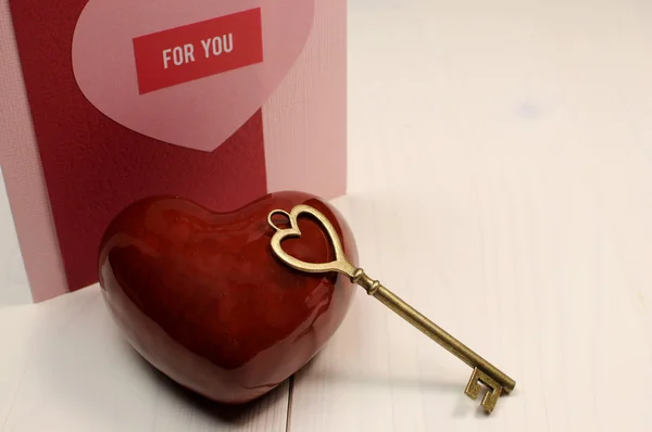 'Key to My Heart' love concept, with gold heart shape key and red heart on white natural wood table with handmade card "For You" message, for Valentine's Day or for someone special. — Stock Photo, Image