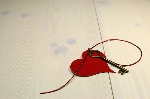 'Key to My Heart' love concept, with gold heart shape key and red heart on white natural wood table, for Valentine's Day or for someone special, with copy space for your text here. — Stock Photo, Image