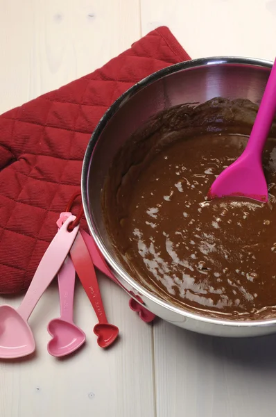 Valentine, ulang tahun atau acara khusus memasak muffin coklat dengan sarung tangan merah dan bentuk hati mengukur sendok pada antik lusuh meja kayu putih alami . — Stok Foto