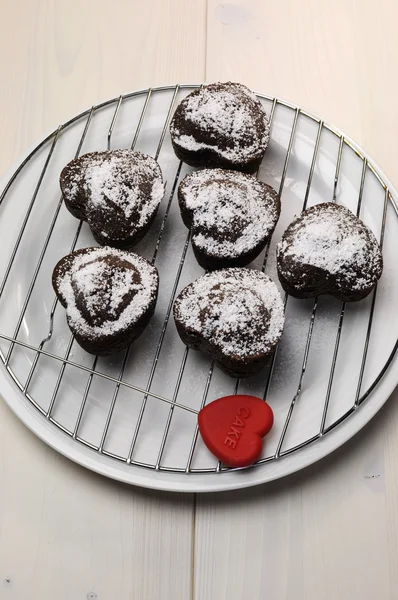 Valentijn, verjaardag of een speciale gelegenheid zelfgemaakte gebakken hart vorm chocolade chip muffins tegen een vintage, shabby chic witte houten tafel. — Stockfoto