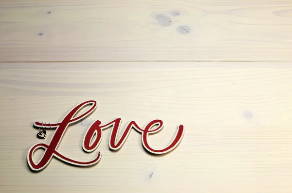 The word, Love, spelled in red script letters on white shabby chic table, horizontal with copy space. — Stock Photo, Image