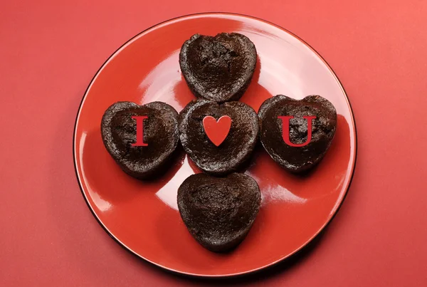 Romantic love theme mini choolate cupcake muffins with letter spelling I Love (heart) You, on red red plate and background. — Stock Photo, Image
