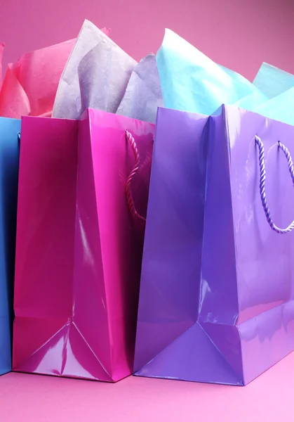 Kleurrijke roze paars en blauw boodschappentassen, zijaanzicht op vrouwelijke roze achtergrond. — Stockfoto