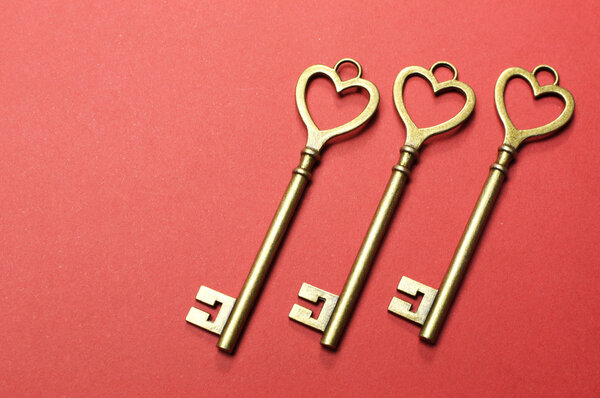 Three 3 gold keys on red background.