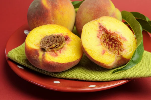 Плита вкусного свежего лета персики фрукты на красной горошек пластины — стоковое фото