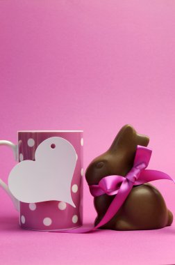 Mutlu Paskalya pembe polka dot kahve veya çay bardağı beyaz kalp şekli hediye etiket işareti ve çikolata bunny ile pembe kurdele ile. Dikey metni buraya Kopyala yeri olan.
