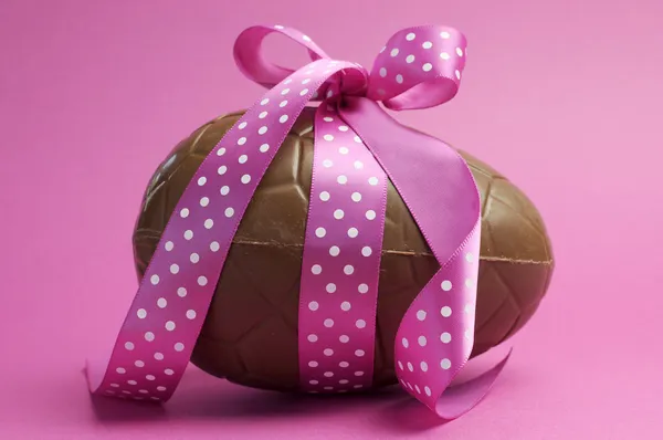 Happy Easter chocolate Easter egg with pink polka dot ribbon tied in a bow Stock Image