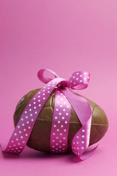 Large Happy Easter chocolate Easter egg with pink polka dot ribbon tied in a bow Stock Image