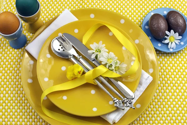 Tema amarelo mesa de jantar de Páscoa com ovos, pintinho e margaridas . — Fotografia de Stock
