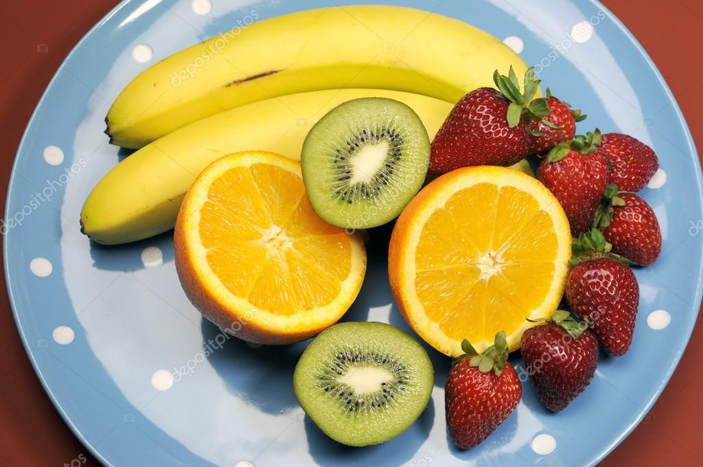 Platter of fruit bananas, orange, kiwi fruit and strawberries on