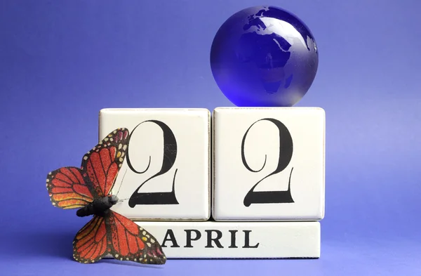 Día de la Tierra, guardar la fecha calendario bloque blanco, 22 de abril, con la mariposa y el globo sobre un fondo azul . —  Fotos de Stock