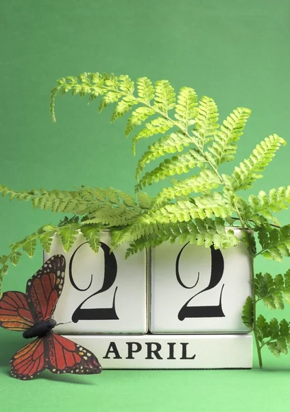 地球日，保存日期白色块日历，4 月 22 日与蝴蝶和蕨类植物的绿色背景。垂直与副本空间. — 图库照片