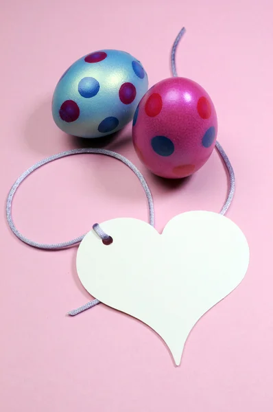 Pink and blue polka dot Easter eggs with white heart gift tag with copy space for your text here. Vertical. — Stock Photo, Image