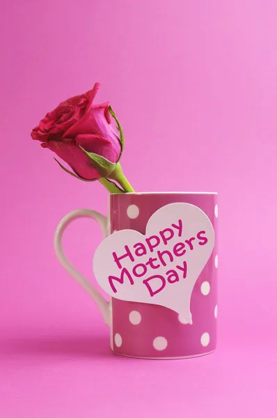 Gelukkig hart gift moeders dag tag op roze polka dot koffie mok met roze roos bud. — Stockfoto
