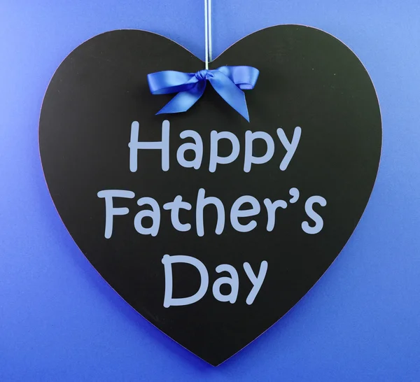 Otců Happy den zpráva napsaná na černé tabuli s modrou stužkou na modrém pozadí. — Stock fotografie
