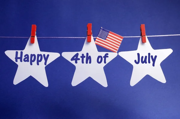 Happy Fourth 4th of July message written across three 3 white stars with USA American flag hanging on red pegs on a line — Stock Photo, Image