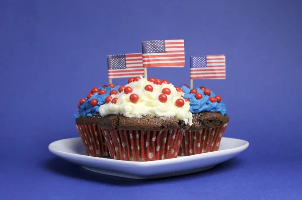 Cuarta fiesta del 4 de julio con cupcakes de chocolate rojo, blanco y azul en plato de corazón blanco y banderas estadounidenses —  Fotos de Stock