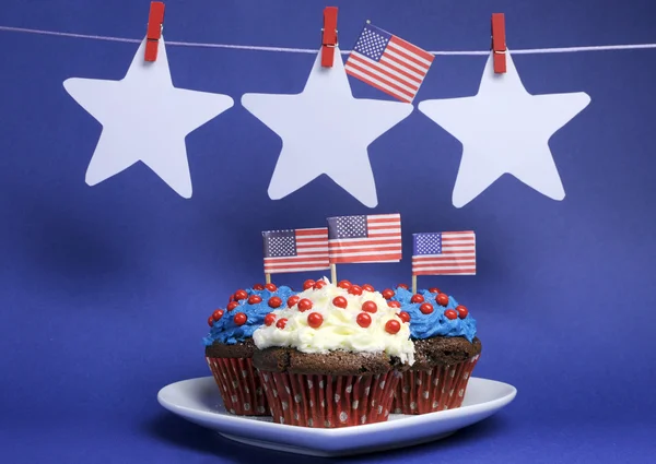 Festa del 4 luglio con cupcake al cioccolato rosso, bianco e blu sul piatto del cuore bianco — Foto Stock