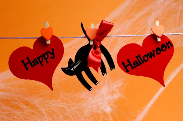 Feliz mensaje de Halloween escrito en corazones rojos y gato negro — Foto de Stock