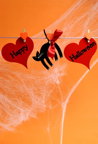 Feliz mensaje de Halloween escrito en corazones rojos y gato negro — Foto de Stock