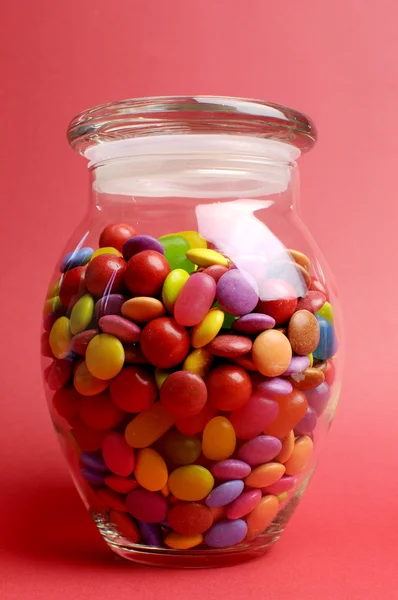 Glass Jar full of bright colorful lollies and candy with closed lid for Christmas or Halloween treats. — Stock Photo, Image