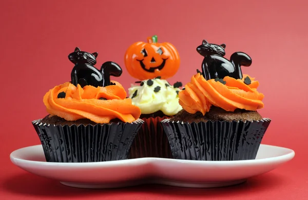 Gelukkig halloween oranje en zwart ingericht cupcakes met zwarte katten en pompoen jack-o-lantaarns — Stockfoto