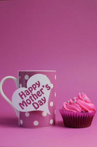 Pink Happy Mother's Day cupcakes gift with message written across white heart signs - with polka dot coffee mug - vertical with copy space. — Stock Photo, Image