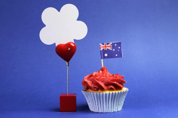 Australian theme red, white and blue cupcake with national flag, and sign for your text here, for Australia Day, Anzac Day or national holiday against a blue background. — Stock Photo, Image