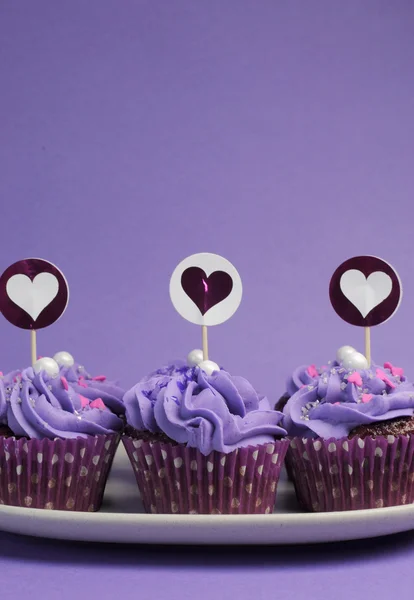 Lila dekorierte Cupcakes für Kindergeburtstage oder Teenagergeburtstage oder Junggesellenabschiede, Braut- oder Babyduschparty. vertikal mit Kopierraum für Ihren Text hier. — Stockfoto